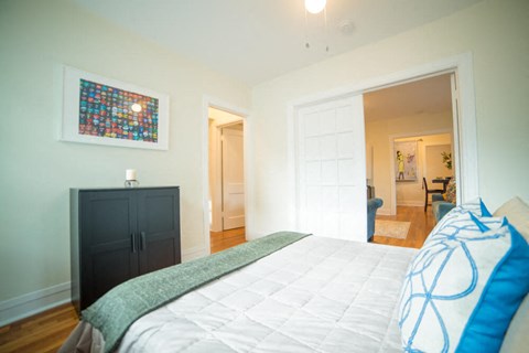 a bedroom with a bed and a door to a living room