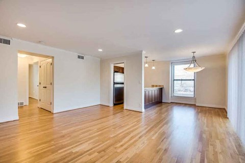 A spacious room with wooden floors and white walls.