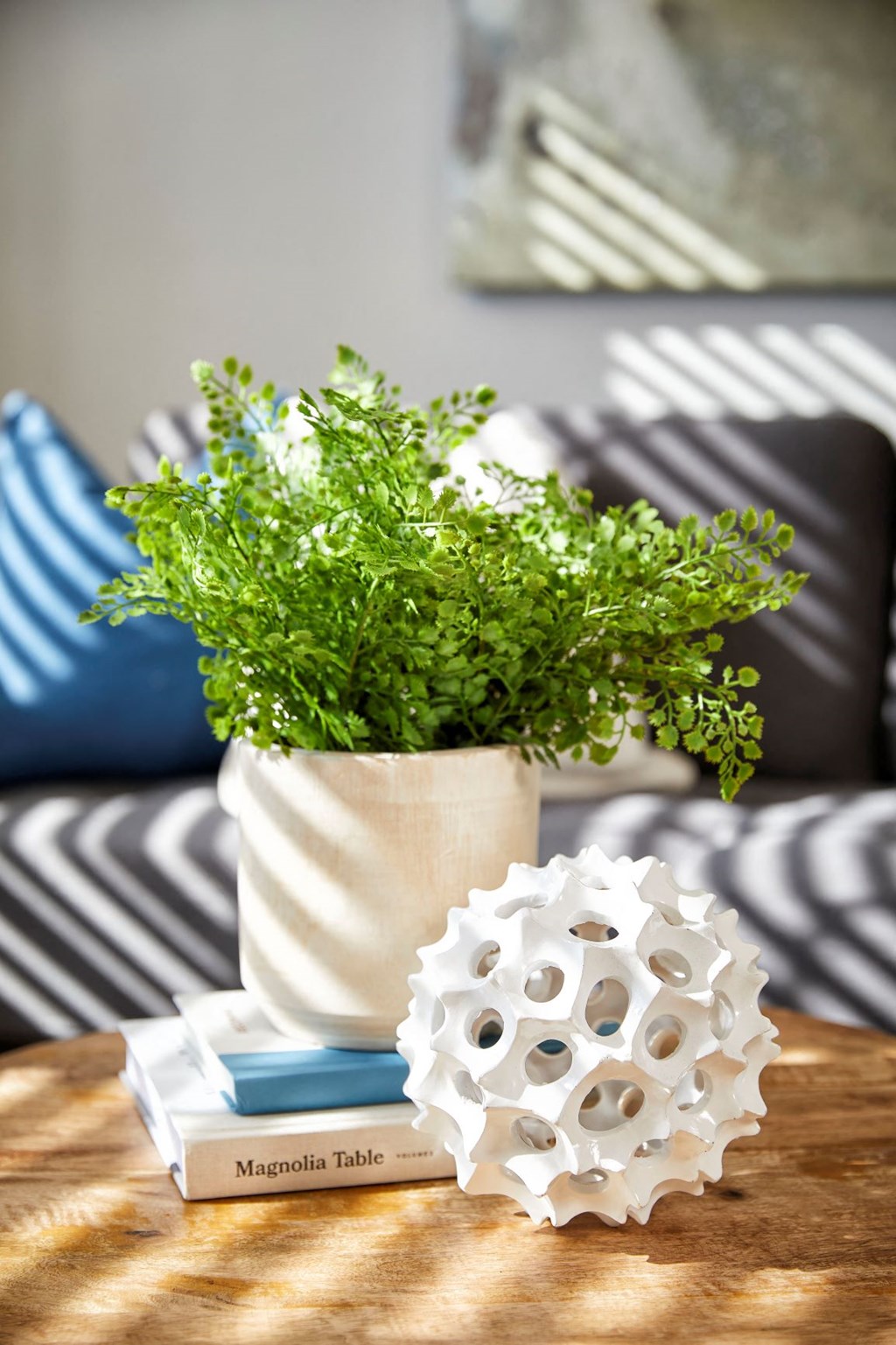 a vase with a plant on a coffee table