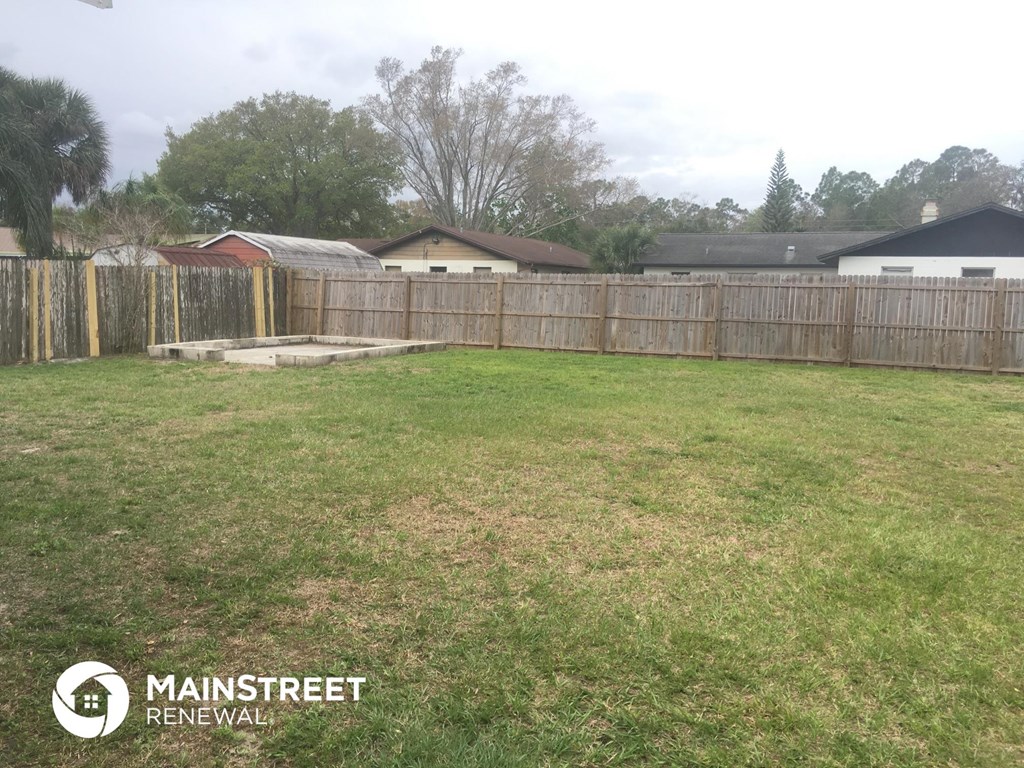 the backyard of a home with a wooden fence