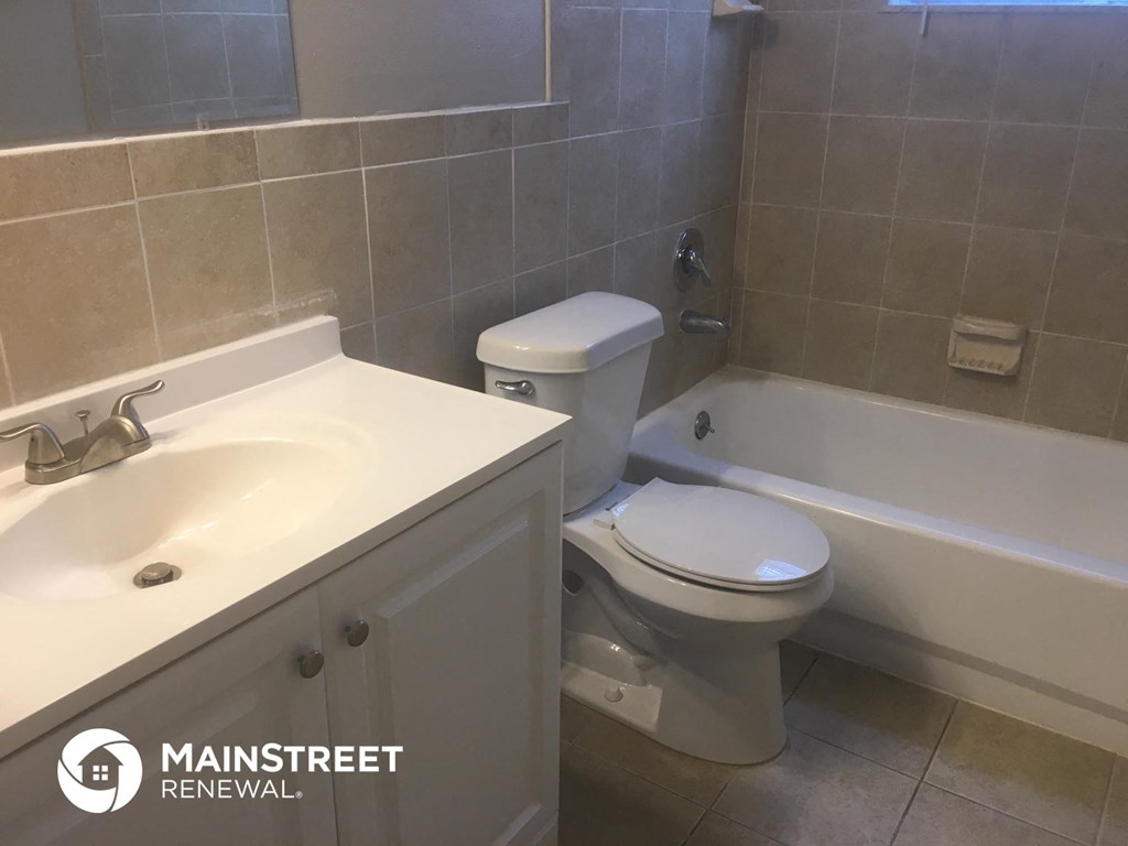 a bathroom with a toilet and a sink and a tub