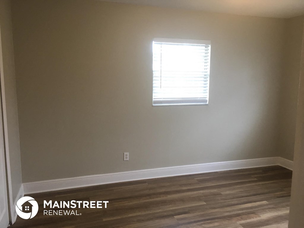 a room with a window and a wooden floor