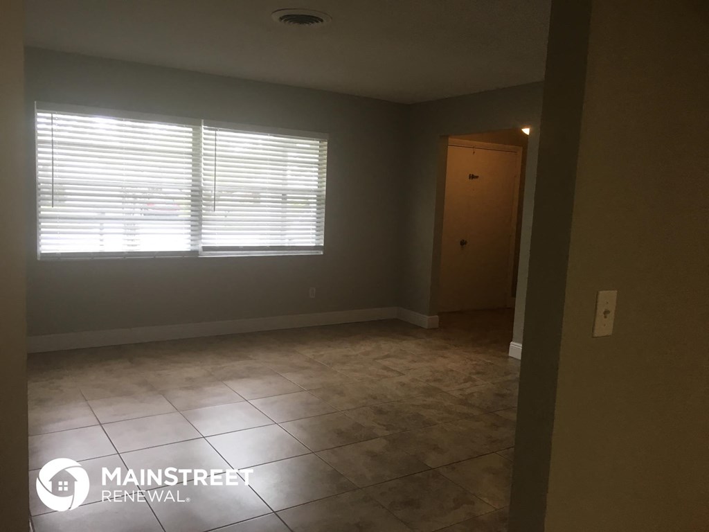 an empty room with a window and a door