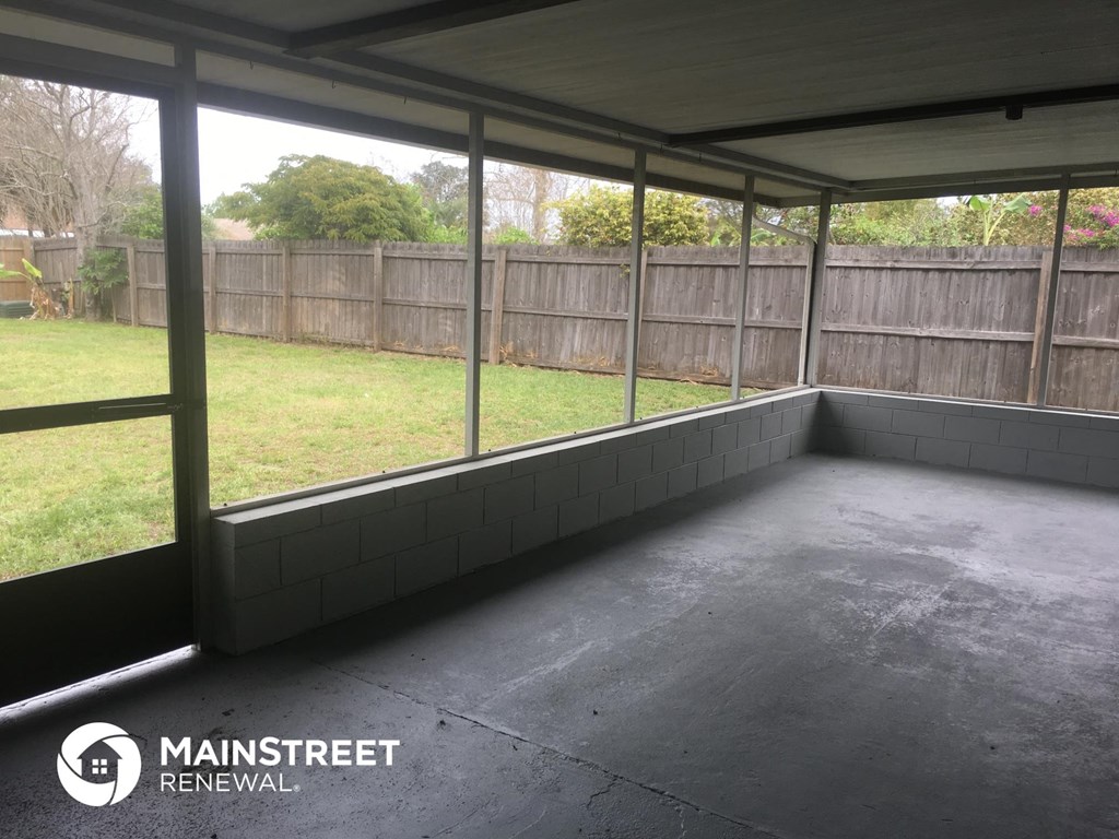 the inside of a screened in porch of a house
