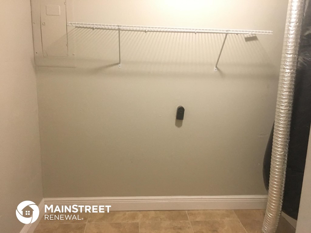 a walk in closet in a bathroom with a shower and a rack on the wall