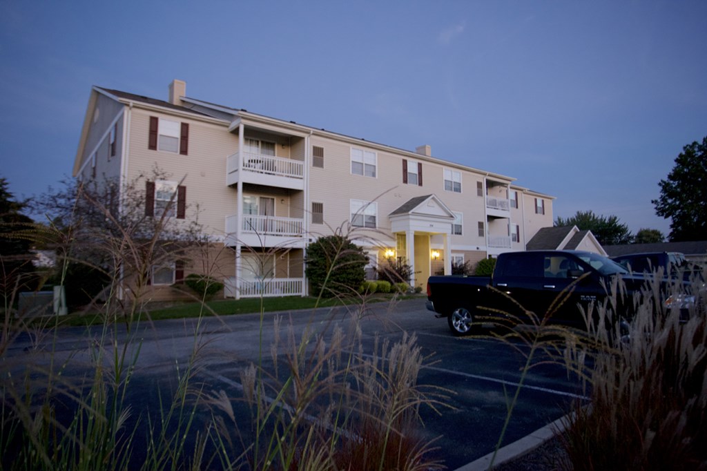 a truck parked in front of an apartment building at night