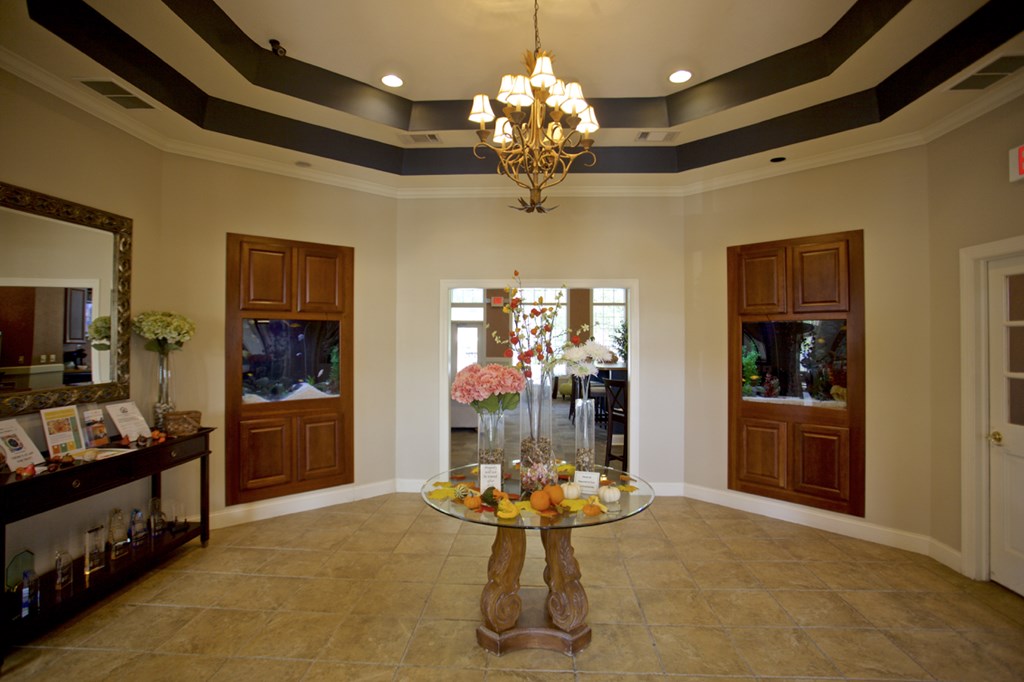 a dining room with a glass table and a chandelier