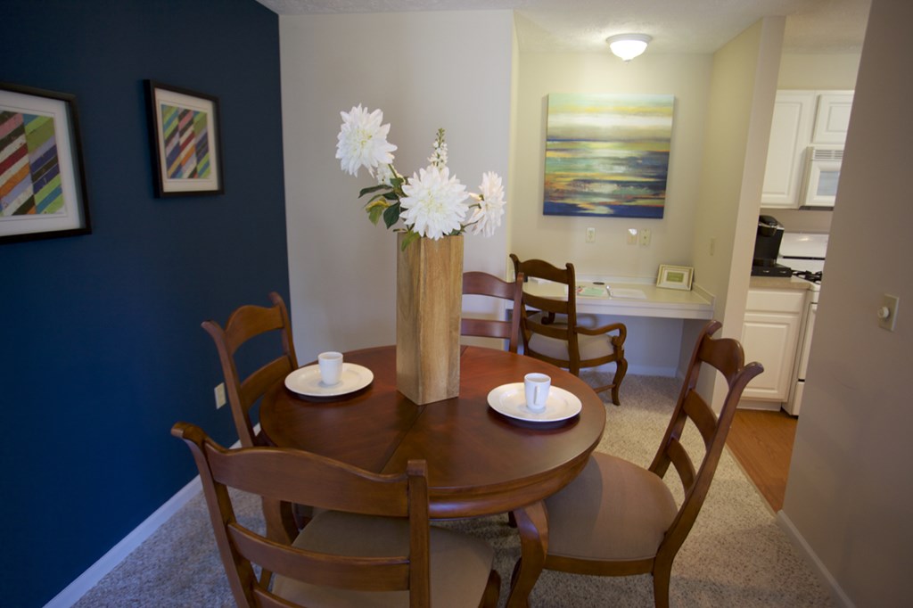a dining room with a table and chairs and a blue wall