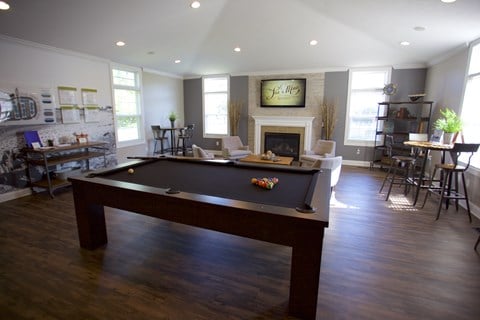 an open living room with a pool table and a fireplace