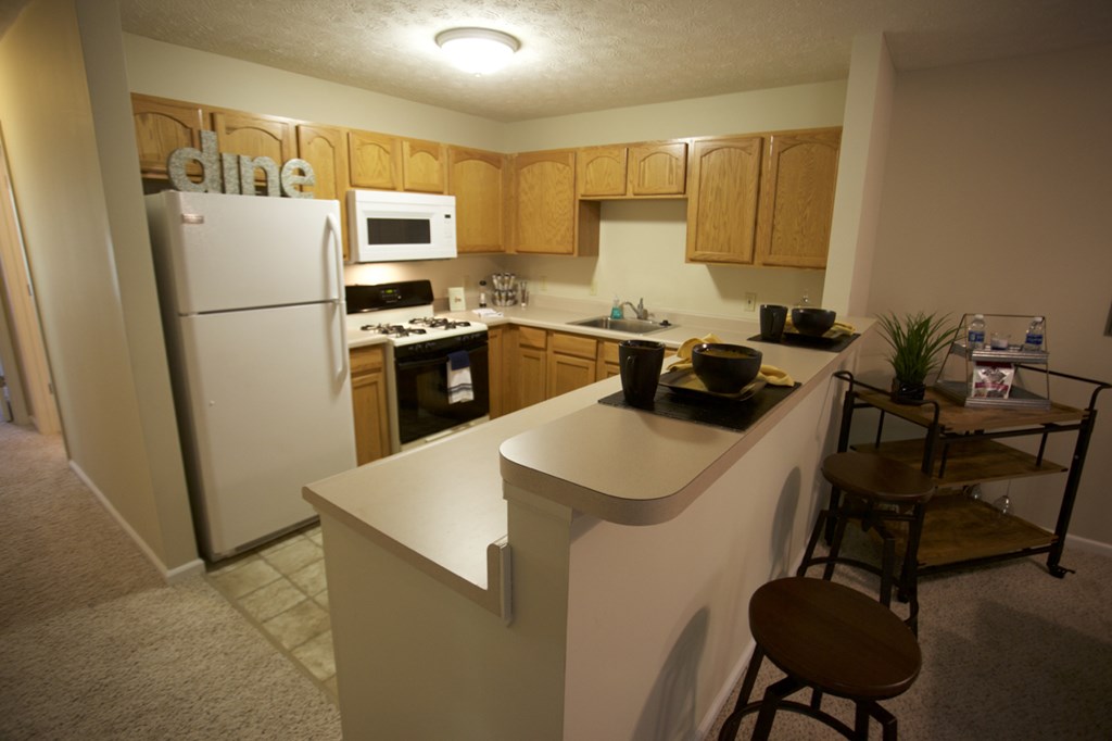 an empty kitchen with a counter and a refrigerator