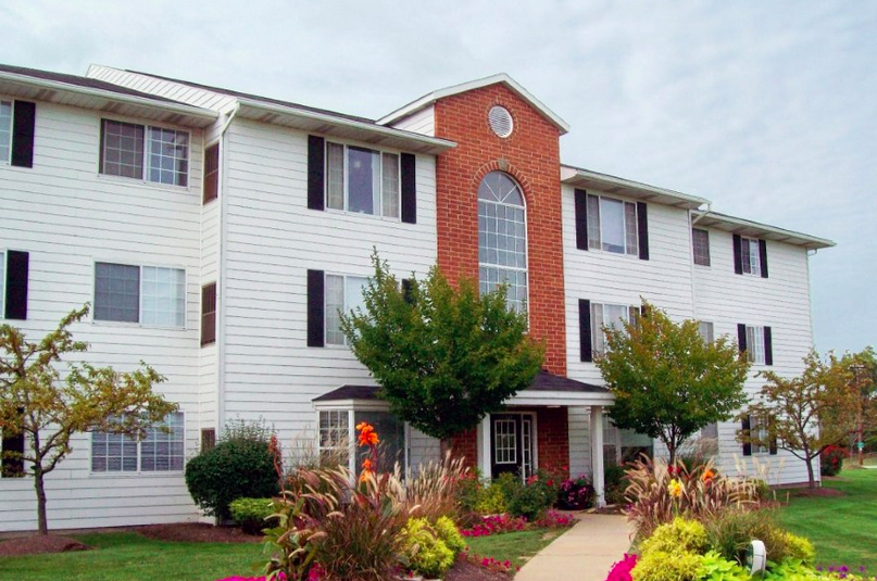 a white house with a red brick chimney and a sidewalk