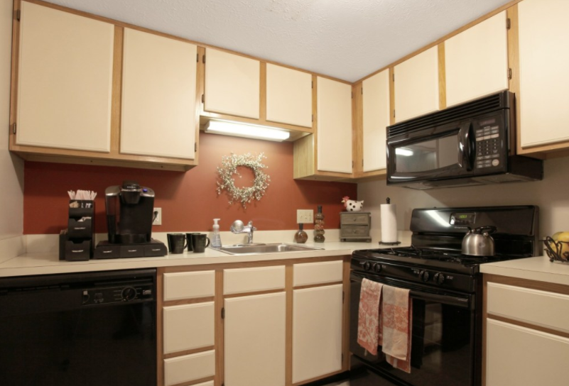 a kitchen with black appliances and white cabinets