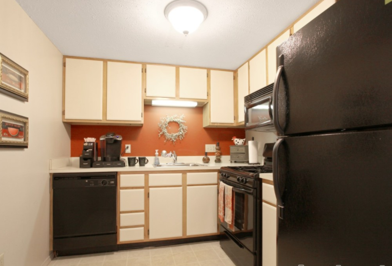 a kitchen with black appliances and white cabinets