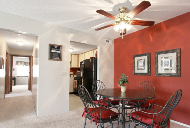 a dining room with a table and chairs and a ceiling fan