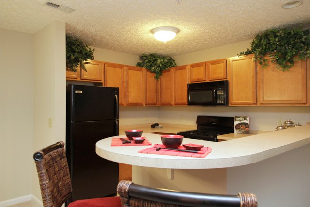 a kitchen with a island and a black refrigerator