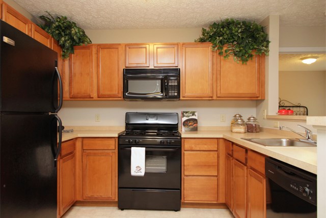 a kitchen with black appliances and wooden cabinets