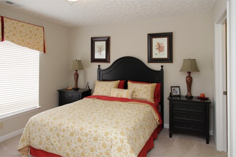 a bedroom with a bed and two night stands and a window