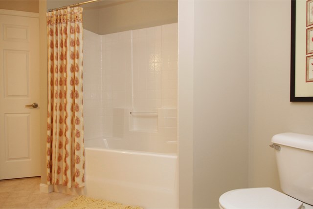 a white bathroom with a shower curtain and a toilet