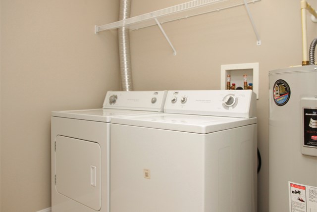 a white washer and dryer in a room with a refrigerator
