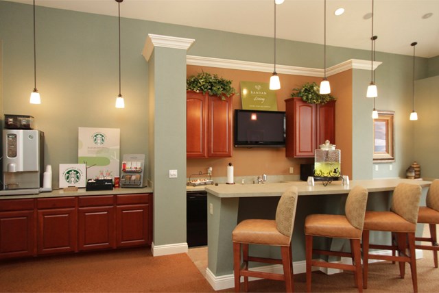a kitchen with a bar and chairs in a living room