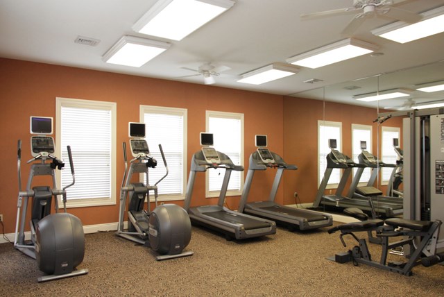 a gym with various exercise equipment in it
