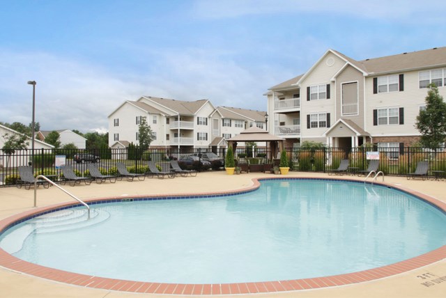 a large swimming pool in front of an apartment building