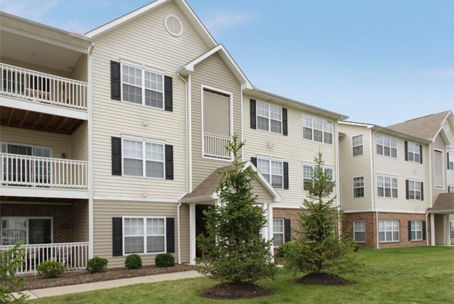 a group of apartment buildings with trees in front of them