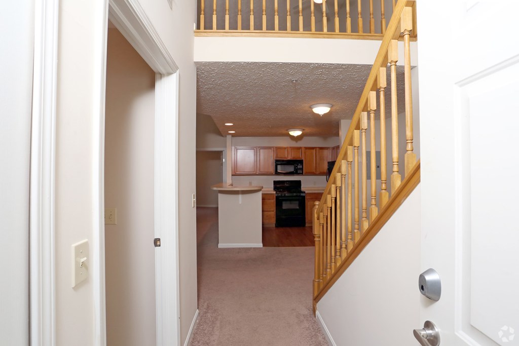 a view of a living room and a kitchen from a staircase