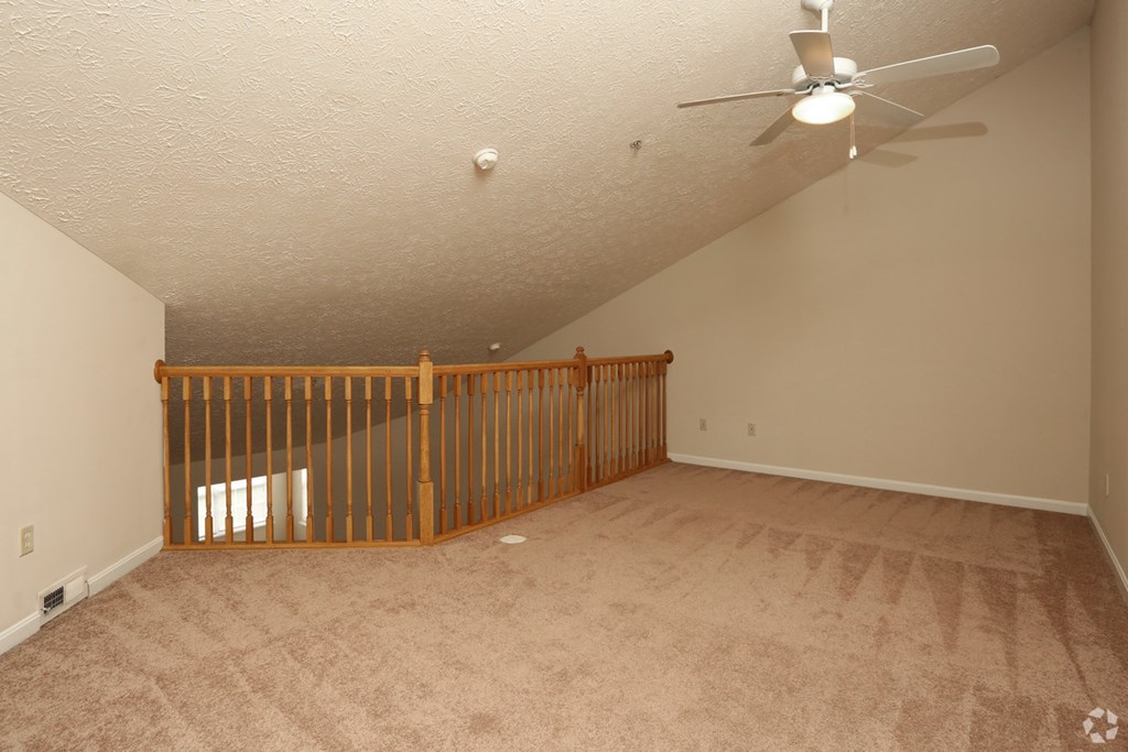 the loft has a crib and a ceiling fan