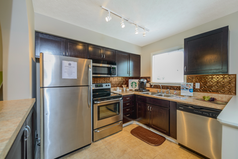 a kitchen with stainless steel appliances and black cabinets
