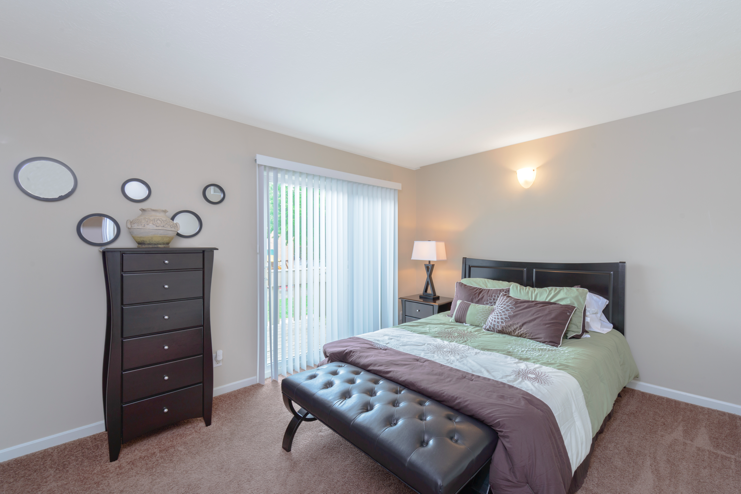 a bedroom with a bed and a dresser and a window