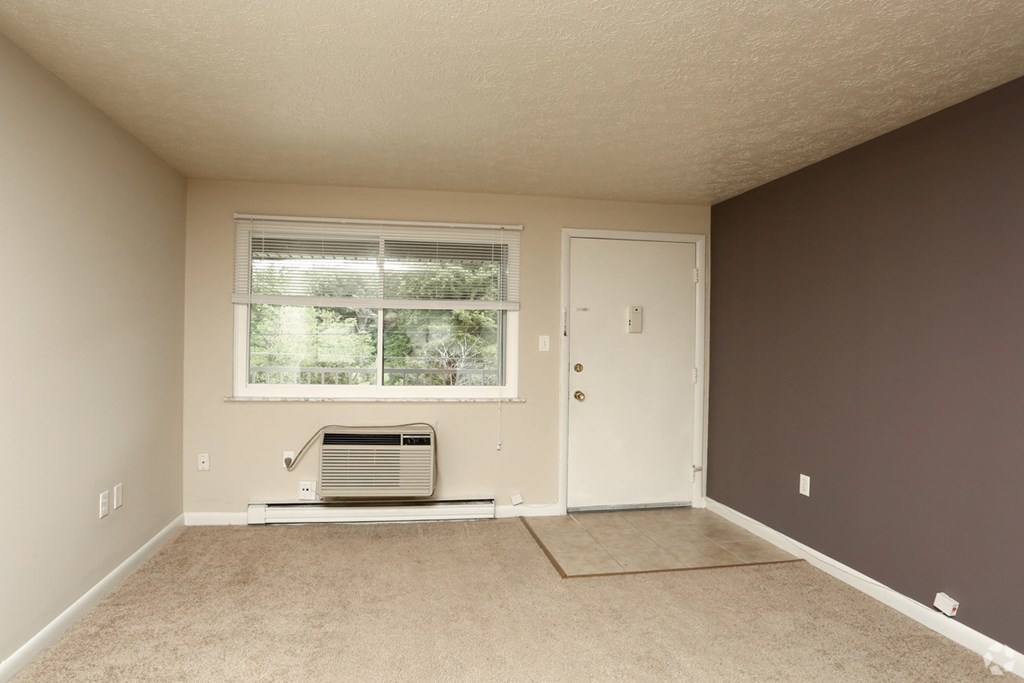 an empty room with a window and a radiator in it