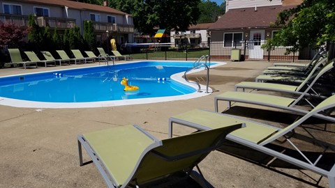 a swimming pool with lounge chairs and chairs around it
