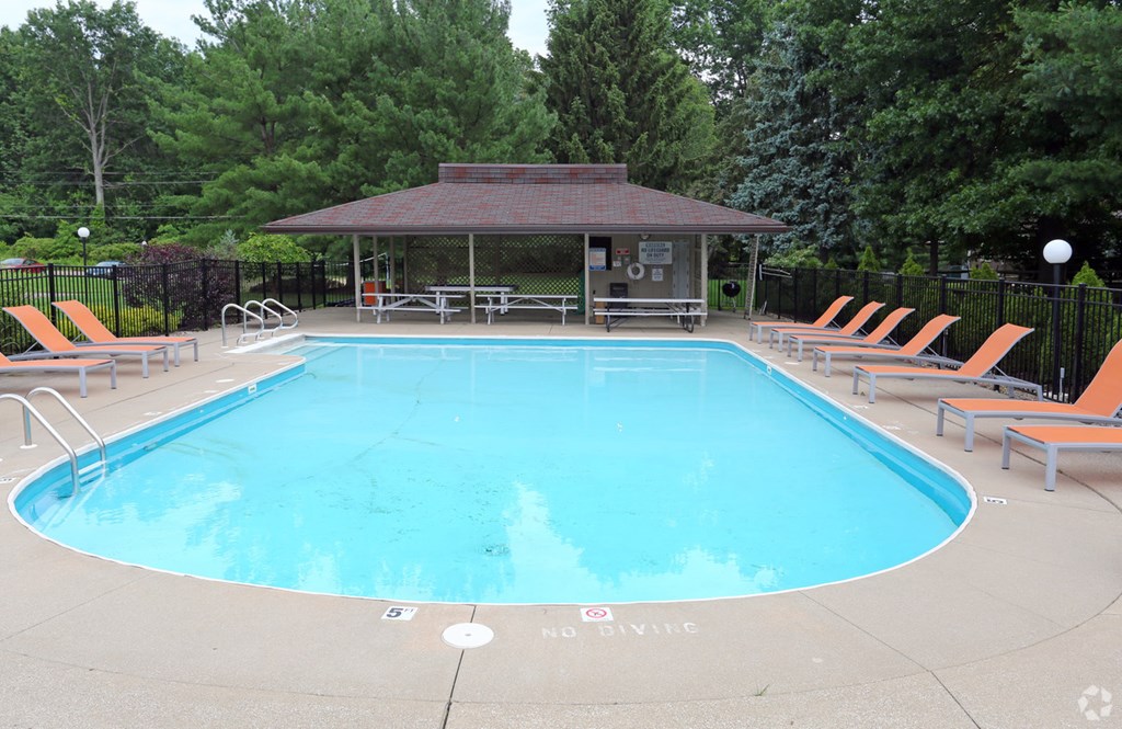 a pool with chairs and a poolside gazebo