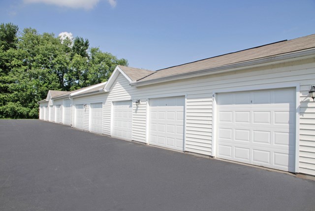 a row of white garage doors on the side of a building
