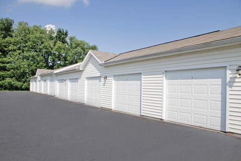 a row of white garage doors on the side of a building