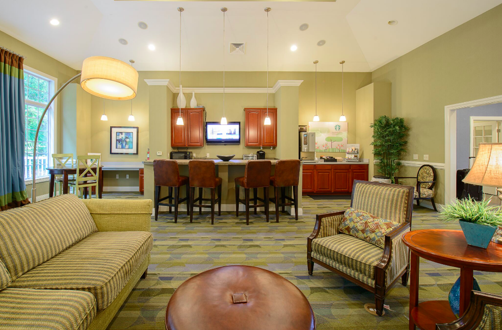 a living room with furniture and a kitchen with a table and chairs