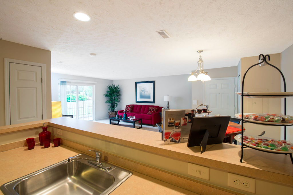 a kitchen and living room with a sink and a tv