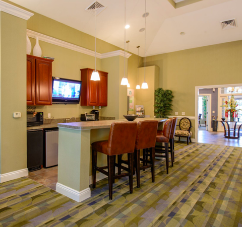 a kitchen with a bar and a living room with a tv