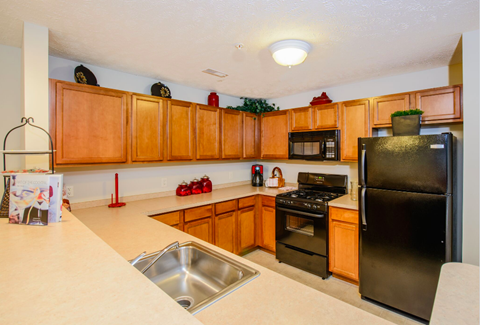 a kitchen with black appliances and wooden cabinets