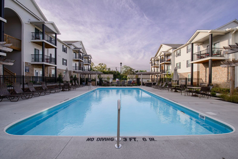 A swimming pool in front of apartment buildings with a sign that says "No Diving 3 FT. 6 M.".