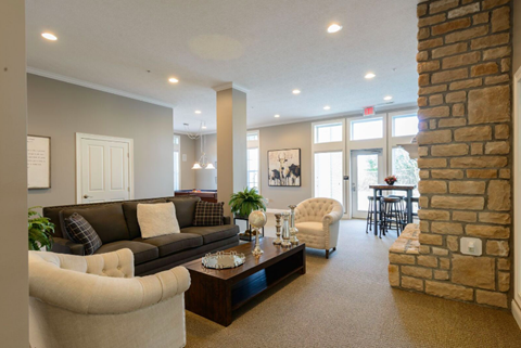 A living room with a grey couch and a white chair.
