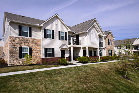 A large house with a grey roof and a white front porch.