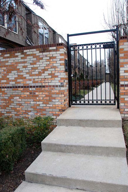 a wrought iron gate in front of a brick wall