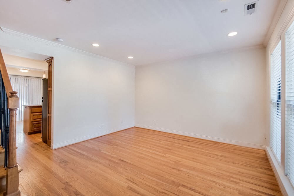 an empty living room with white walls and wooden floors