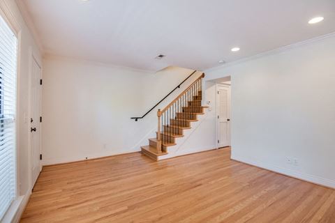 a living room with wood floors and a staircase