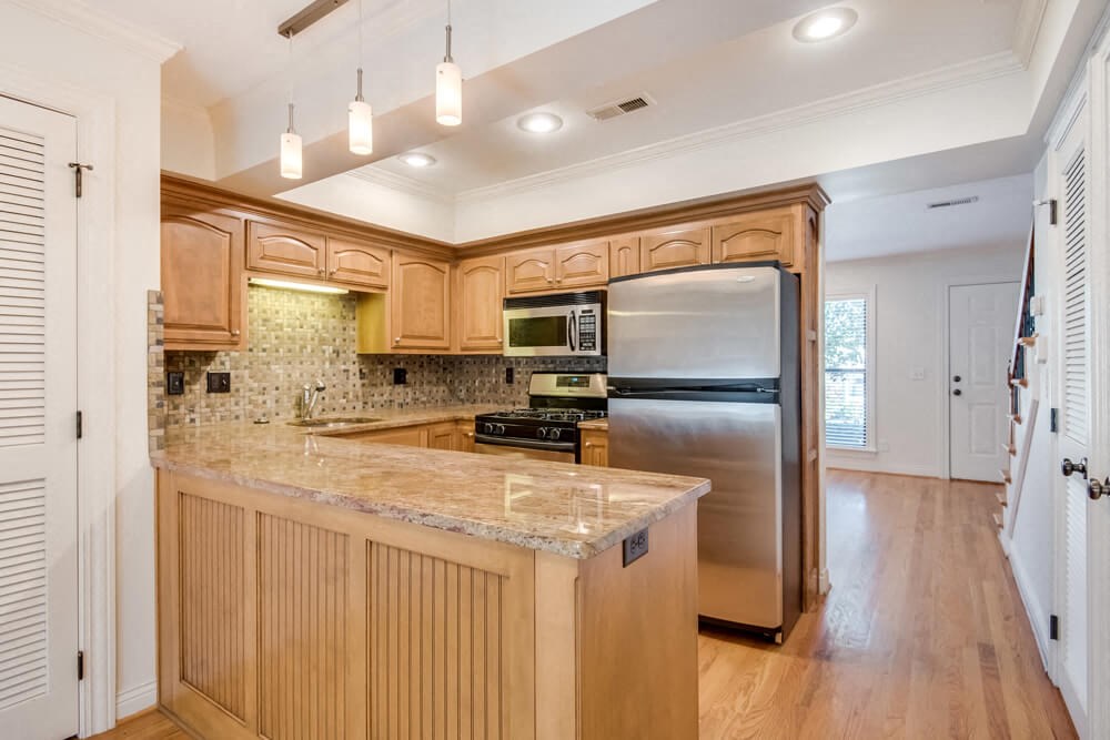 a kitchen with wooden cabinets and a stainless steel refrigerator