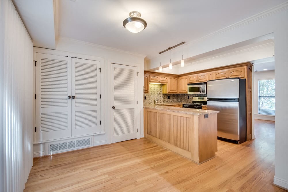 a kitchen with wooden cabinets and a stainless steel refrigerator