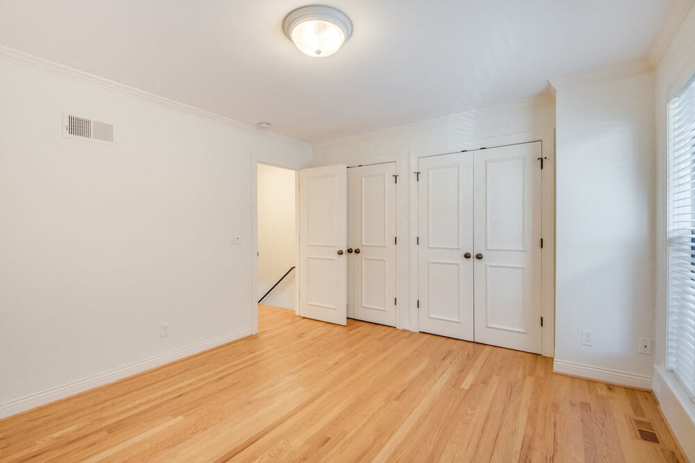 an empty living room with white walls and wood floors