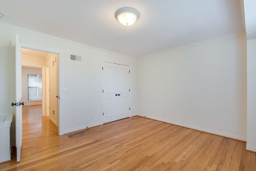 an empty living room with white walls and wood floors